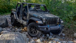 Gray entry-level Jeep Wrangler 4xe parked in the middle of a rocky off-road trail.