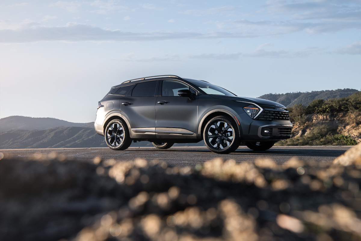 A grey 2023 Kia Sportage PHEV parked in a desert area. 