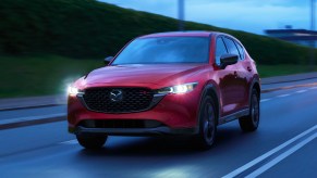A red 2023 Mazda CX-5 is driving on the road.