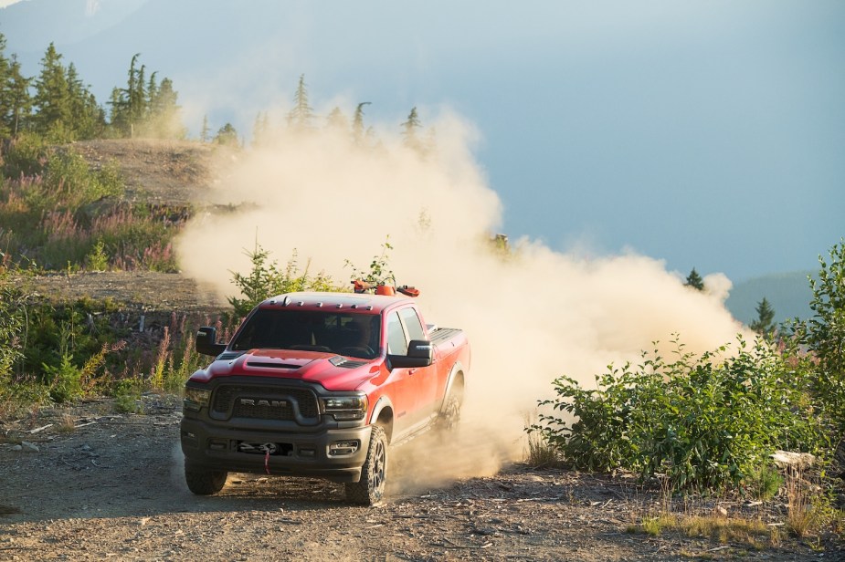 Promo photo of the Ram 2500 Rebel pickup truck navigating an off-road trail, a cloud of dust visible behind it.