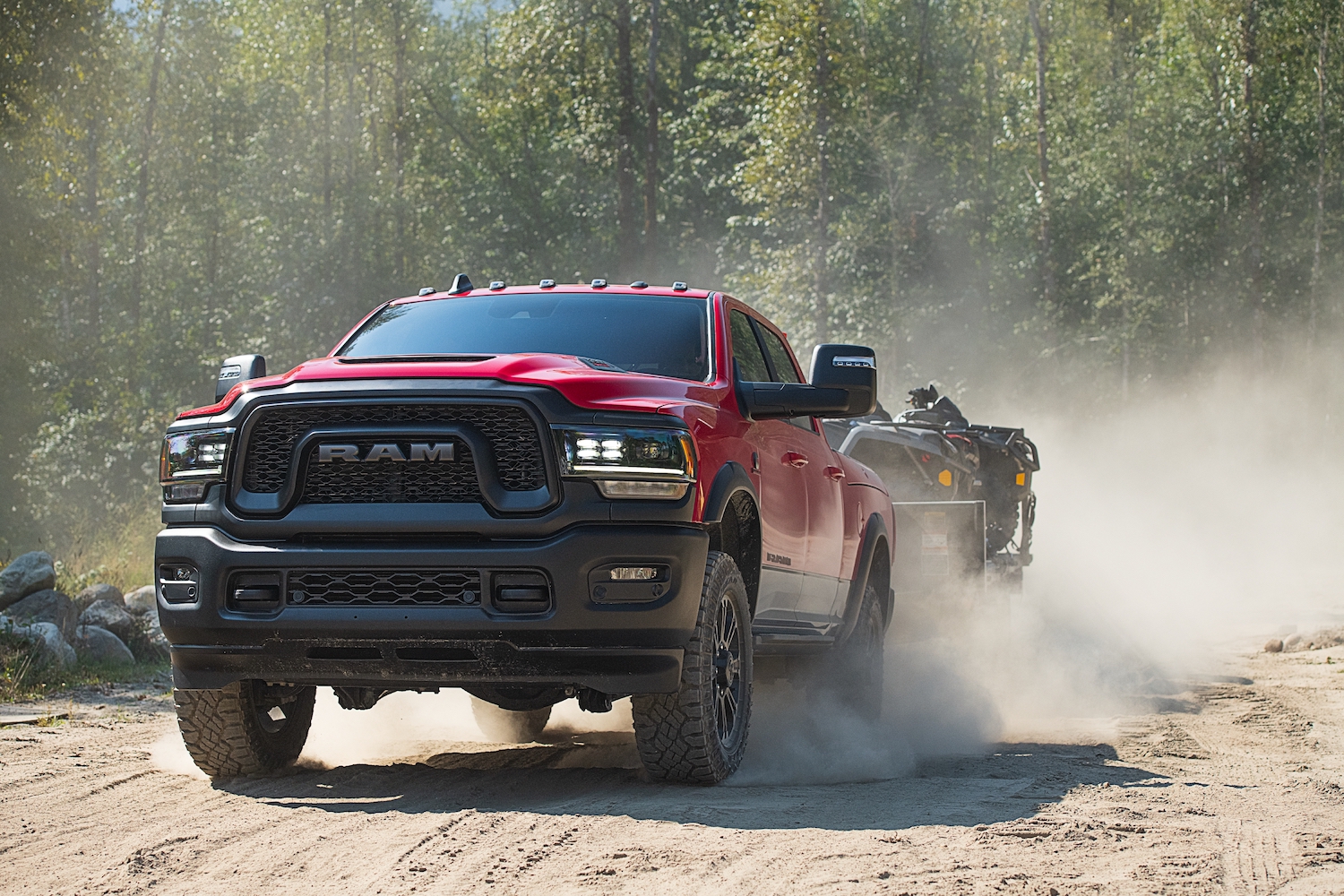 The heavy-duty Ram 1500 rebel 4x4 truck demonstrates its tow rating by pulling a trailer off-road.
