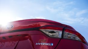 The rear badging of a red 2023 Toyota Corolla Hybrid model