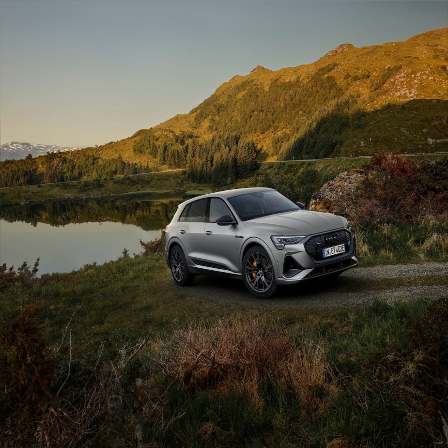 A silver 2023 Audi e-tron, an all-electric SUV models, driving through the countryside. 