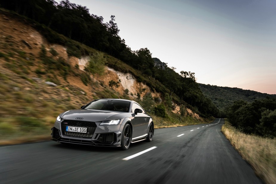 A gray Audi TT RS is a solid AWD sports car, just like the V8-powered Jaguar F-Type R.