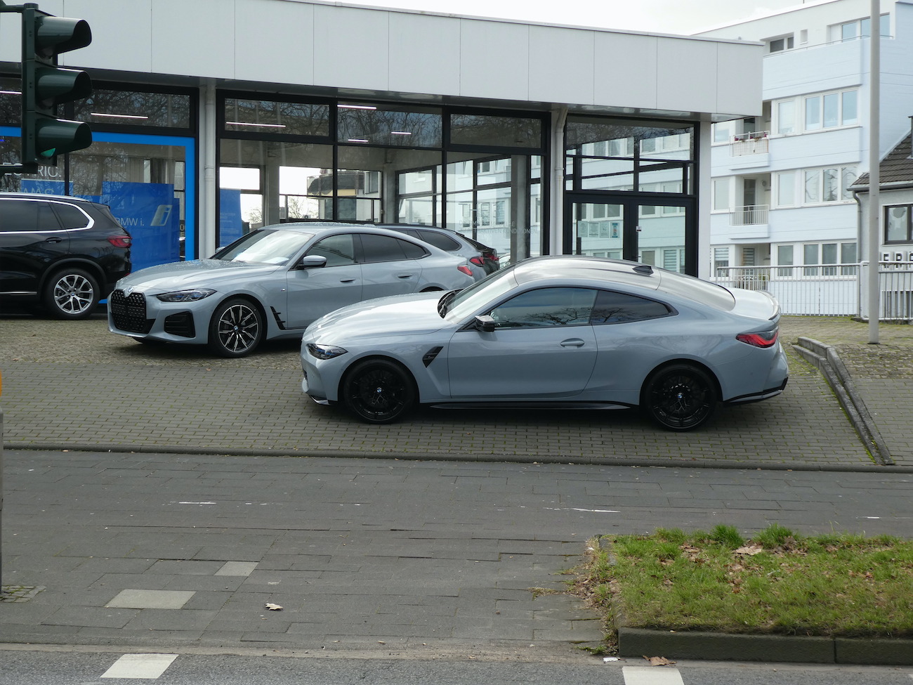A BMW 4 Series in front of a dealership.