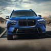 A blue 2023 BMW X7 three-row SUV drives on a road during the day. What's new with it?
