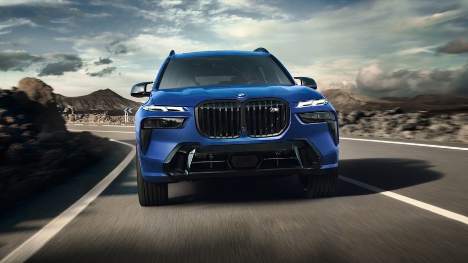 A blue 2023 BMW X7 three row SUV drives on a road during the day.  What's up with it?