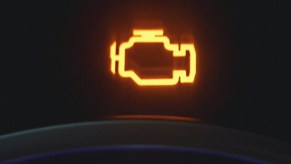 Check engine light on dashboard gauge of car, highlighting how it can be caused by loose gas cap