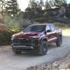 A red 2023 Chevy Colorado Trail Boss shows off its capability as a mid-size truck.