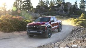 A red 2023 Chevy Colorado Trail Boss shows off its capability as a mid-size truck.