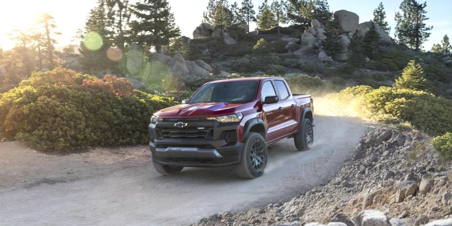 A red 2023 Chevy Colorado Trail Boss shows off its capability as a mid-size truck.