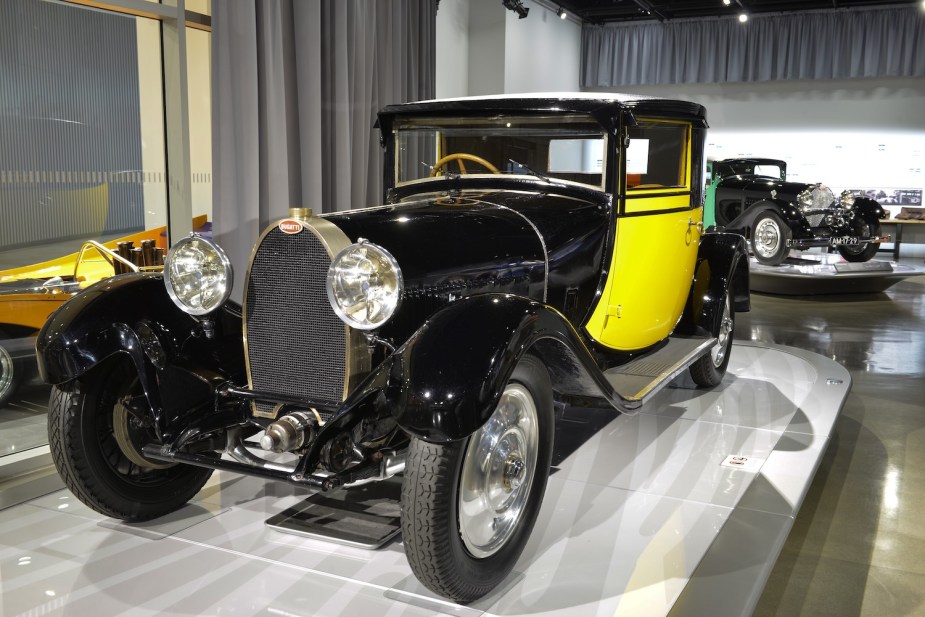A black and yellow 1929 Bugatti coupe body on a Type 44 chassis parked at the Petersen automotive museum.