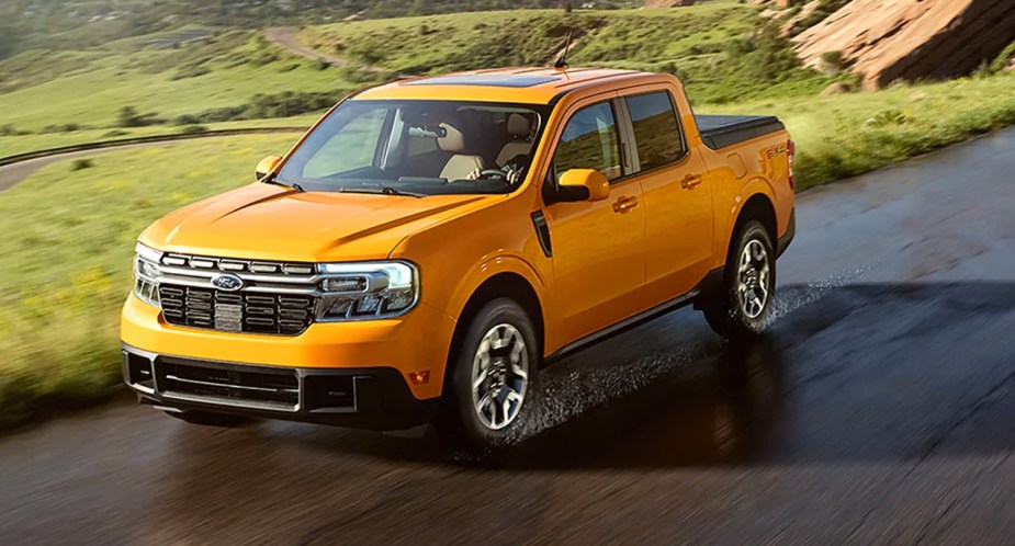 A yellow Ford Maverick small pickup truck is driving on the road. 