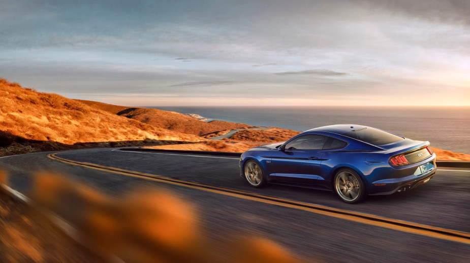 The S550 Ford Mustang blasts down a coastal road.