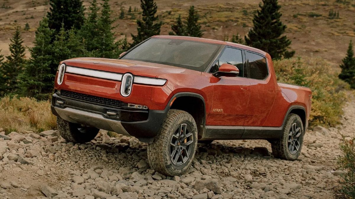 Front angle view of orange-red 2023 Rivian R1T electric pickup truck