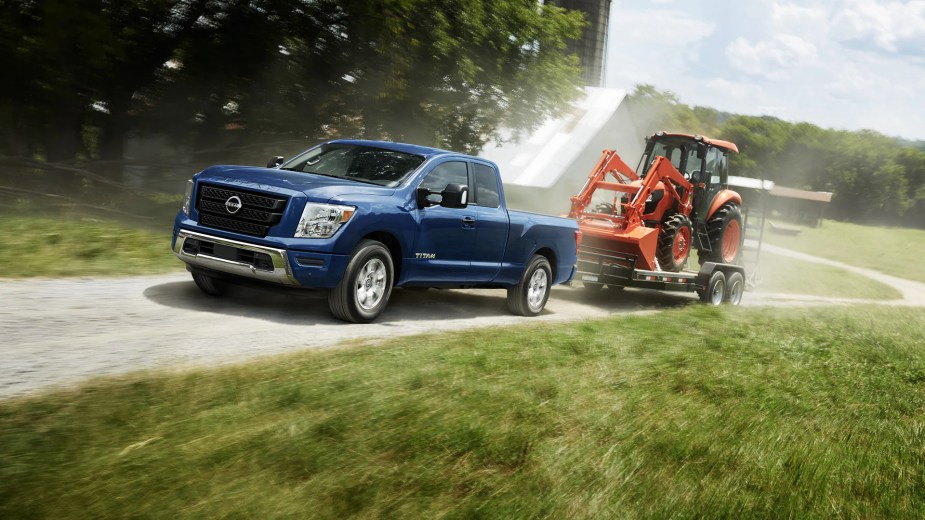 A 2023 Nissan Titan SV tows a piece of machinery.