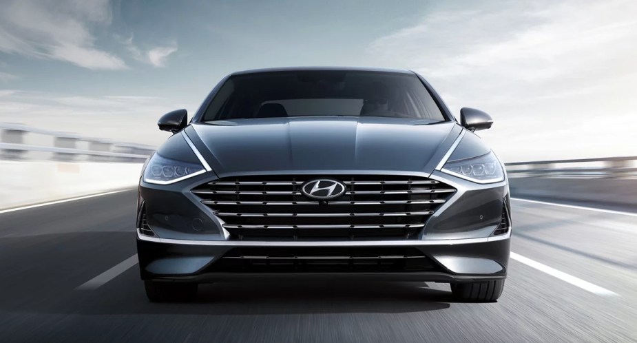 A gray Hyundai Sonata Hybrid midsize hybrid car is driving. 