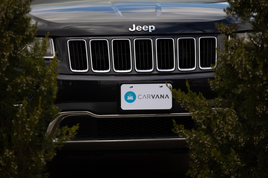 A Jeep's front grille is shown in close proximity with a Carvana logo as the license plate.