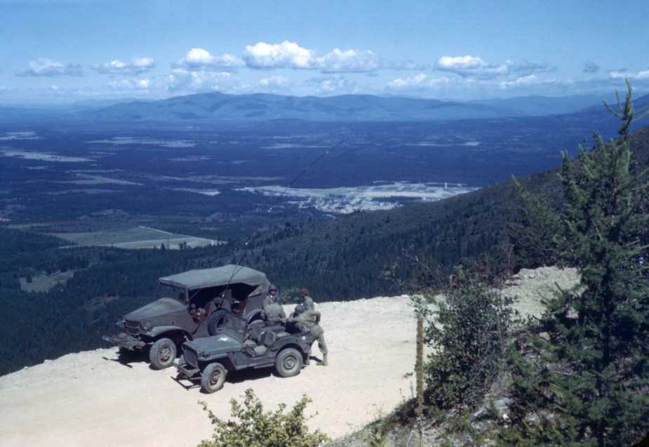 Old photo of a Dodge Command Car and Willys Jeep MB parked on a mountain road during a WWII training exercise in Idaho.