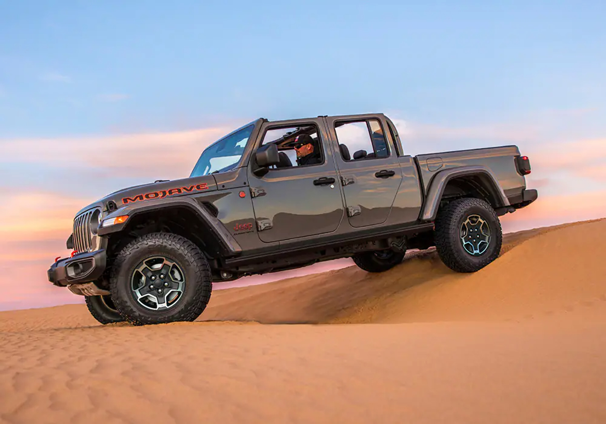 A 2023 Jeep Gladiator Mojave shows off its capability in a desert as a mid-size truck.