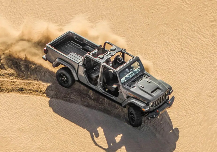 A Jeep Gladiator with its top down drives in the desert.