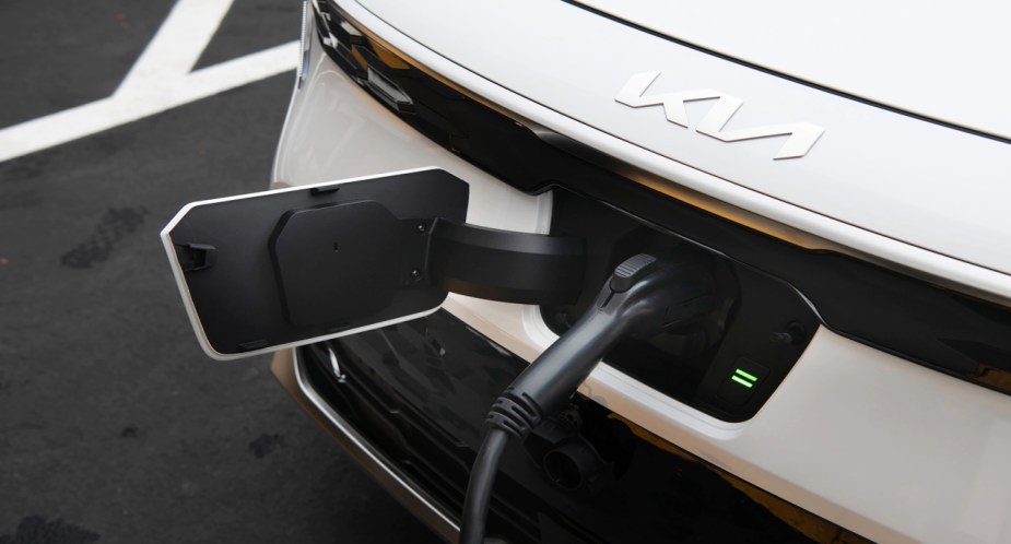 A white 2023 Kia Niro EV electric subcompact SUV is charging. 