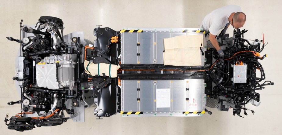 Overhead view of a Volkswagen technician wiring a lithium-ion battery in the chassis of an ID.3 EV.