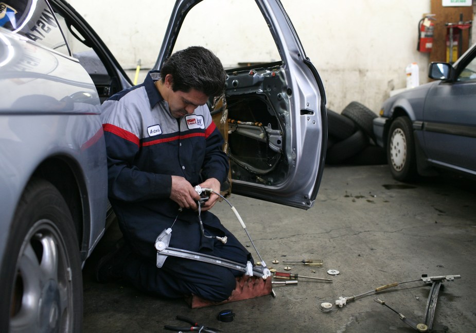 A mechanic works on a window assembly passenger door. How much does it cost to replace a car window motor?