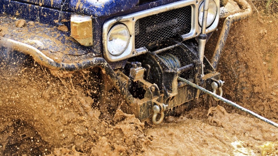 Off road winch in use pulling a truck out of the mud