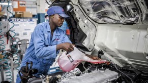 A person pouring antifreeze that could possibly have to clean up an antifreeze leak,