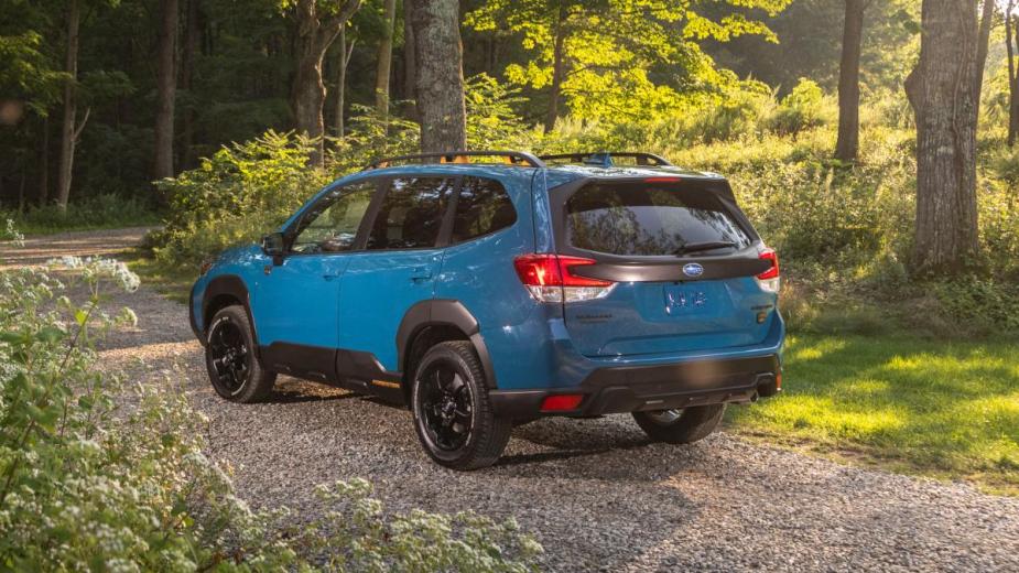 Rear angle view of blue 2023 Subaru Forester crossover SUV, highlighting its price and when it will be available
