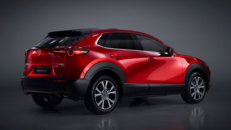 Rear angle view of new red 2023 Mazda CX-30 crossover SUV, highlighting its price and release date