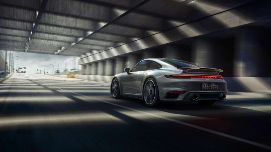 Rear angle view of new silver 2023 Porsche 911 Turbo S sports car, highlighting how much fully loaded one costs