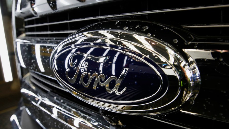 Closeup of the Ford Blue Oval logo on the chrome grille of reliable used F-150 American truck.
