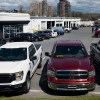 A row of reliable used pickup trucks including a Dodge Ram 1500 and Ford F-150, parked in a dealership lot.
