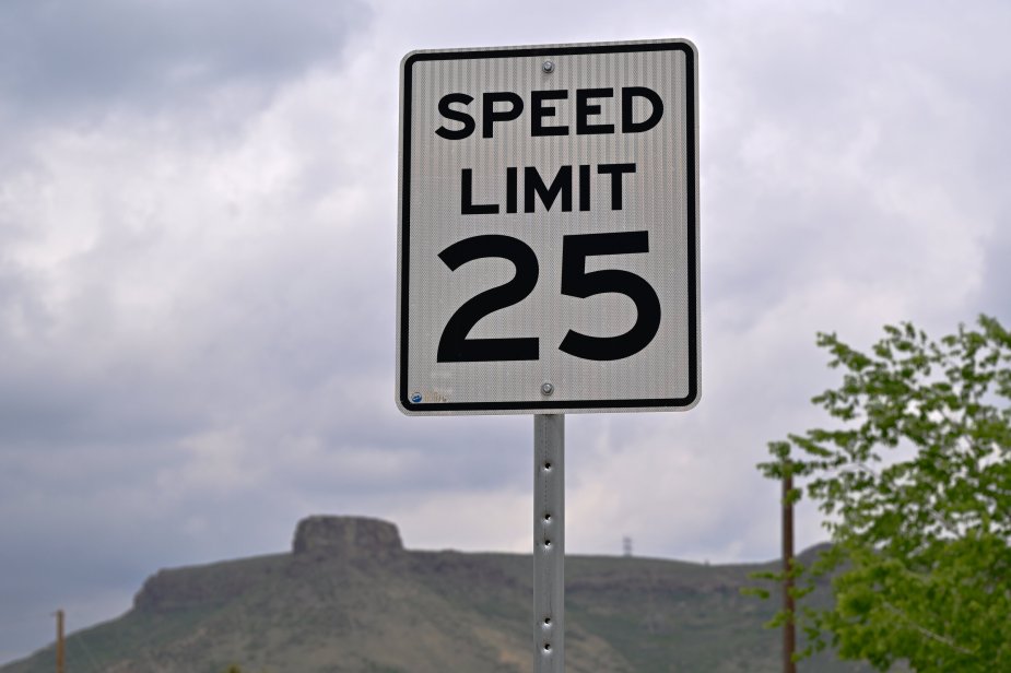A 25 mph speed limit sign on the side of a road. Federal regulators want to limit your car's speed.