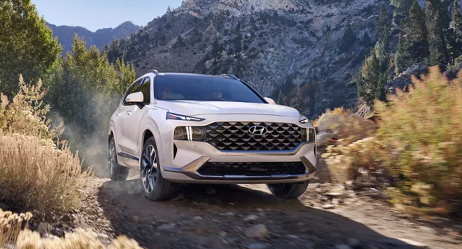 A white 2023 Hyundai Santa Fe midsize SUV is driving off-road. Could it have engine problems?