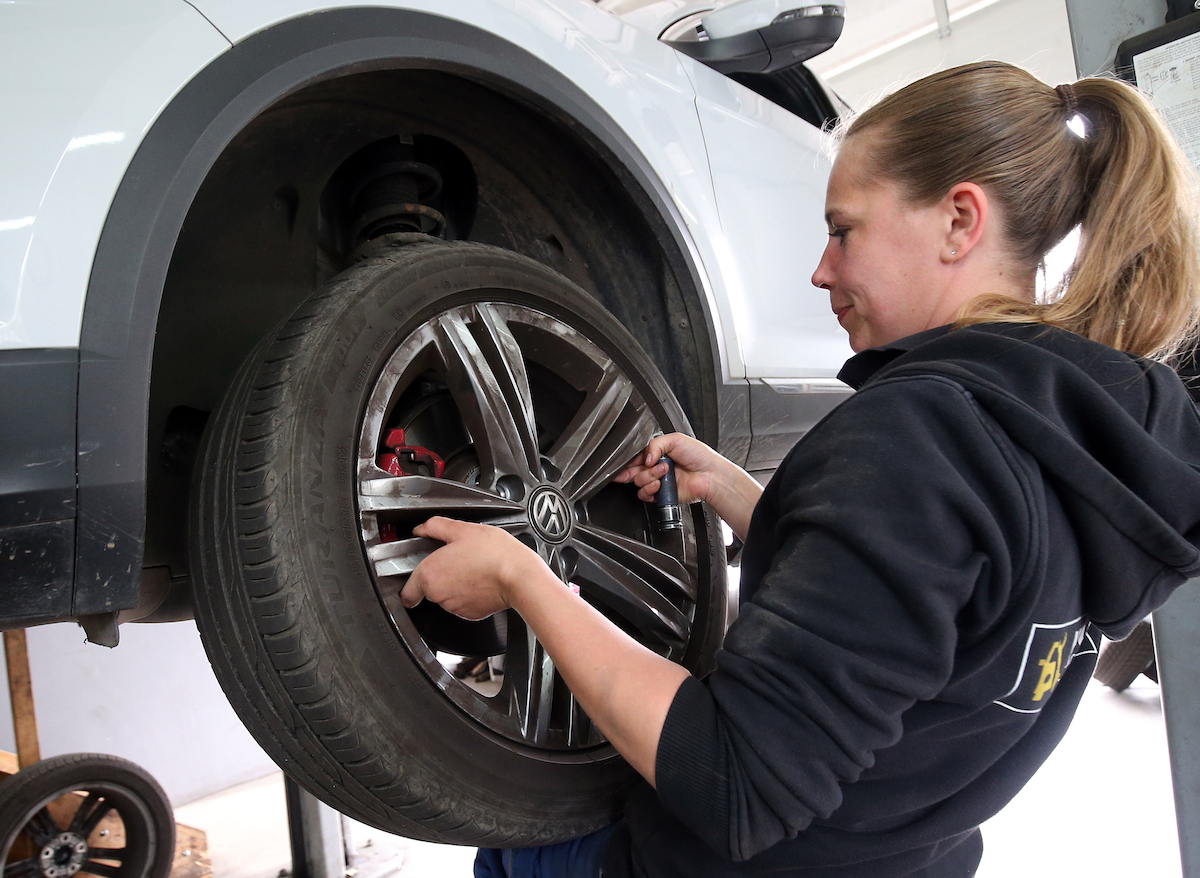 A person getting tires put on, potentially after buying used tires.