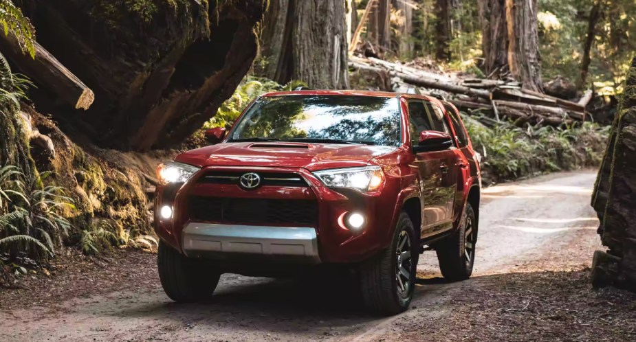 A red Toyota 4Runner is driving off-road. 
