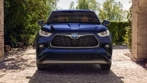 A blue 2023 Toyota Highlander Hybrid midsize hybrid SUV is parked.