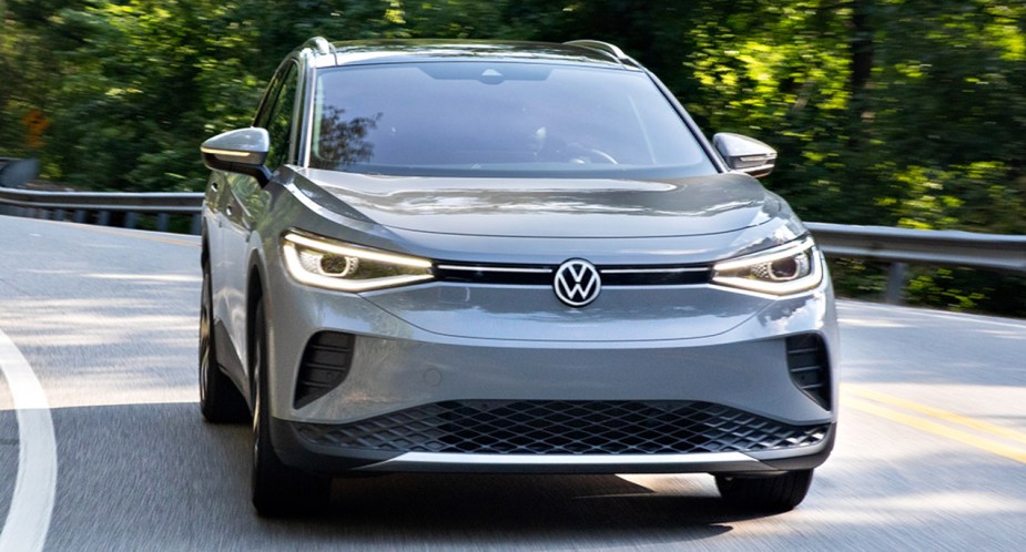 A gray 2023 Volkswagen ID.4 small electric SUV is driving on the road. 