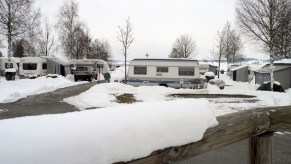A group of campers parked in the snow, potentially winterizing your camper if parked here would be a good idea.