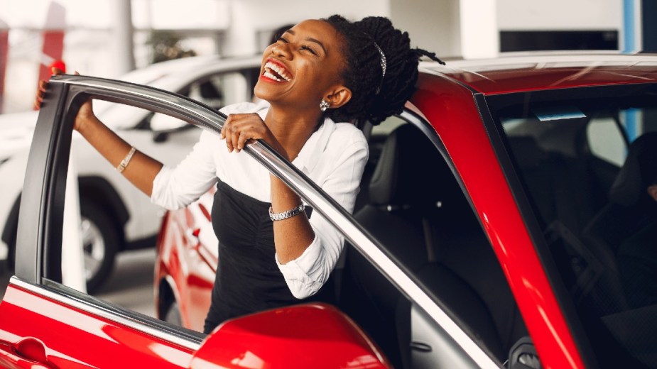 Woman Smiling After Buying a Red Car