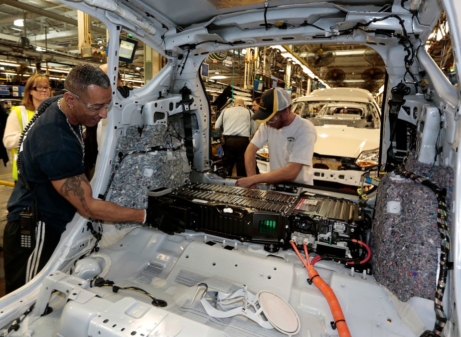 Michigan factory workers install the battery in a Ford C-Max hybrid car.