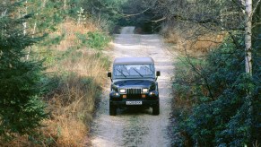 Jeep Wrangler driving down a dirt road