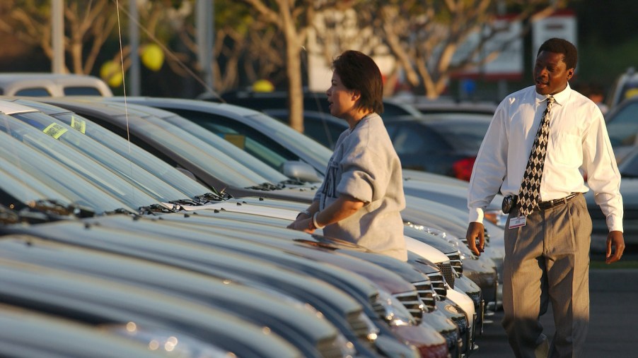 A customer looks over a car on the dealer lot.