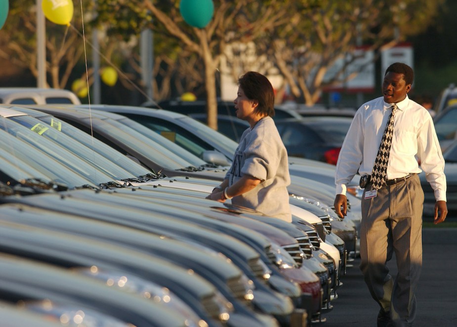 A customer looks over a car on the dealer lot.