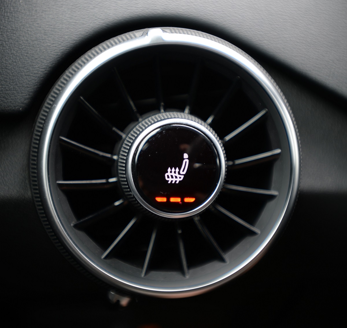 A dialed car seat heater control is shown on max setting.