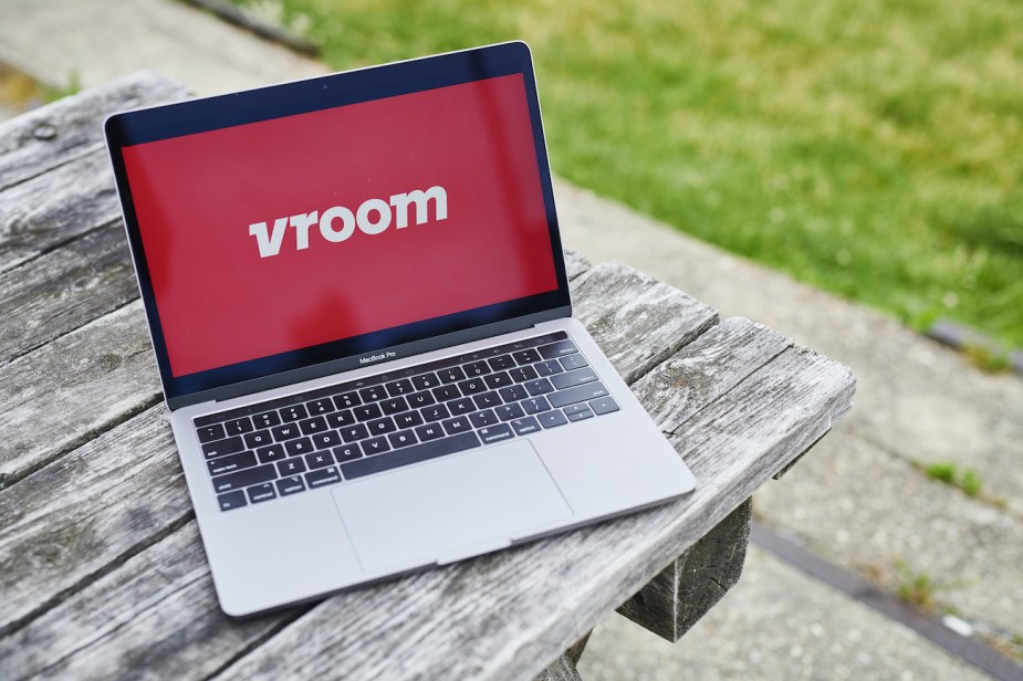 The logo for Vroom Inc. is displayed on a laptop computer.