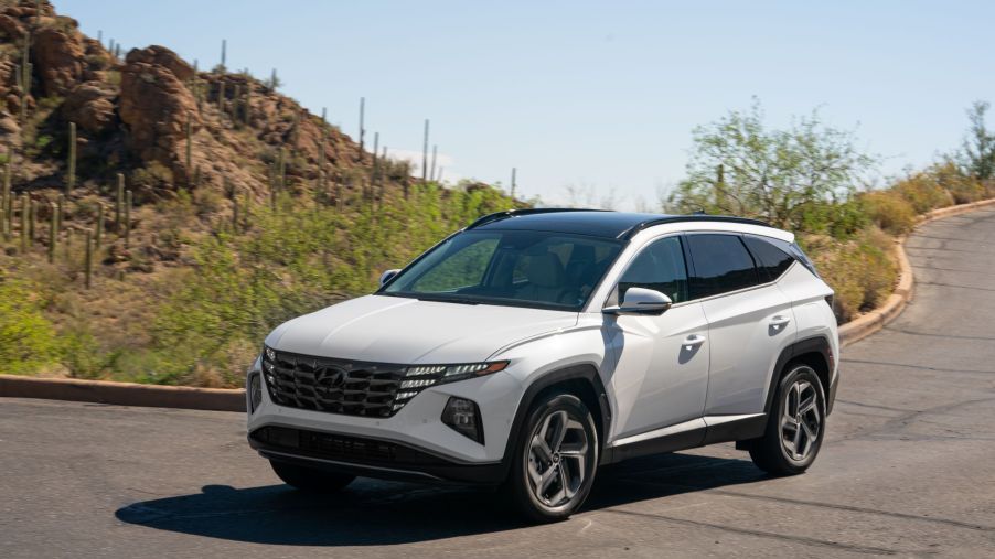 A white 2022 Hyundai Tucson Hybrid compact SUV model parked near a desert cliff